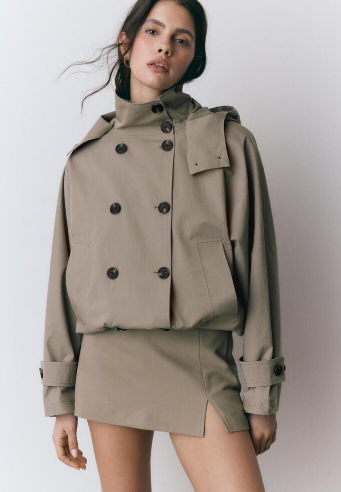 Kurzes Trenchcoat mit Puffärmeln und abnehmbarer Kapuze Kurzes Trenchcoat mit Puffärmeln und abnehmbarer Kapuze